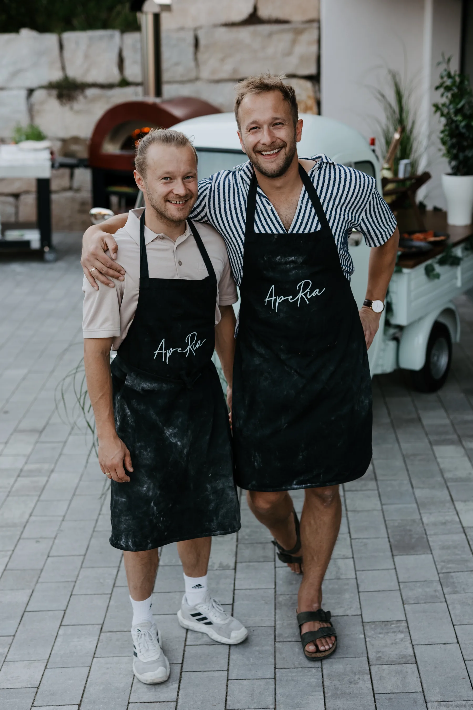 Das ApeRia Team in den Schürzen vor Ape und Holzofen